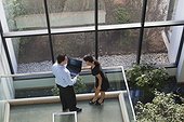Business couple looking at computer in office lobby