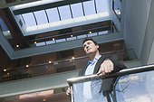 Businessman standing on the stairwell of an office building atrium