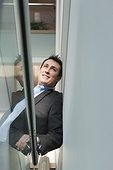 Businessman leaning on the stairwell of an office building