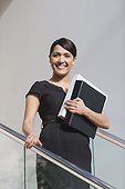 Businesswoman holding folders on stairs of office building