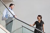 Business couple talking on stairs of office building