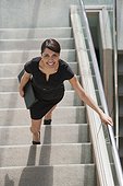 Hispanic businesswoman going up stairs of office building