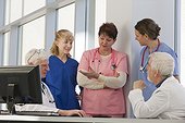 Nurses and doctors discussing patients while at computer