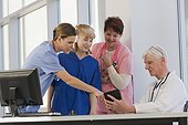 Three nurses discussing information from tablet with doctor