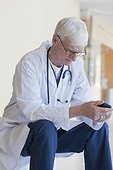 Doctor reading a text message on mobile phone