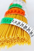 Uncooked spaghetti tied with a tape measure