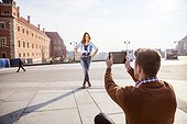 Mid adult man taking a picture of girlfriend