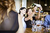 Two women taking a selfie in restaurant