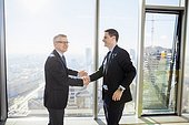 Two businessmen shaking hands in modern office