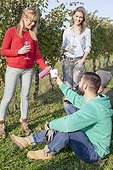Group of friends drinking white wine on garden party in vineyard