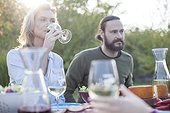 Woman drinking red wine on garden party