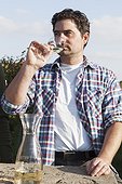 Man tasting wine in his vineyard