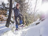 Girl snowshoeing in Black Forest under bright sunlight, Germany, Europe