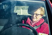 Happy old woman driving a car