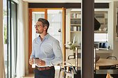 Thoughtful businessman drinking coffee at home
