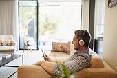 Man with headphones and mp3 player listening to music at home