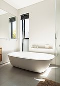 Soaking tub in tranquil, modern home showcase bathroom