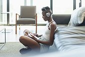 Young woman listening to music with headphones and digital tablet in living room
