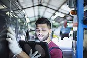 Focused male mechanic using digital tablet in auto repair shop