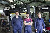 Portrait confident male mechanics in auto repair shop