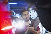 Male mechanic with clipboard working in auto repair shop