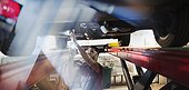 Male mechanic working under car in auto repair shop