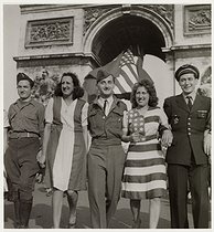 Roger-Viollet | 157224 | US soldiers and French women wearing dresses with the colours of the French and American flags, in front of the Arc de Triomphe, present place Charles-de-Gaulle-Etoile. Paris (VIIIth, XVIth, XVIIth arrondissement), 1945. Photograph by Roger Schall (1904-1995). Paris, musée Carnavalet. | © Roger Schall / Musée Carnavalet / Roger-Viollet