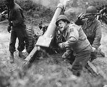 Roger-Viollet | 185643 | World War II. American howitzers shell german forces retreating near Carentan, France. July 11, 1944. | © US National Archives / Roger-Viollet