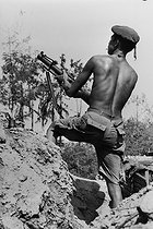 Roger-Viollet | 246732 | Fighter of the People's Movement for the Liberation of Angola attacking the Portuguese troops with a grenade launcher. Angola (Black Africa), 1975. | © Succession Demulder / Françoise Demulder / Roger-Viollet