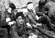 Roger-Viollet | 324596 | World War II. American assault troops of the 16th Infantry Regiment, injured while storming Omaha Beach, wait by the chalk cliffs for evacuation to a field hospital for further medical treatment. Colleville-sur-Mer, Normandy, France. June 6, 1944. | © US National Archives / Roger-Viollet