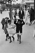 Roger-Viollet | 379277 | Children back from the shops. Mohammedia (Algeria), 1967. Photograph by Jean Marquis (1926-2019). | © Jean Marquis / Roger-Viollet
