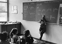 Roger-Viollet | 389865 | Spelling lesson. Example: Une petite fille née dans une rose (A little girl was born in a rose). Paris suburbs. 1967. Photograph by Janine Niepce (1921-2007). | © Janine Niepce / Roger-Viollet