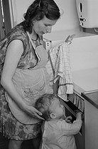 Roger-Viollet | 434642 | Woman and her cihld in one of the first HLMs (French subsidised housing). Vitry-sur-Seine (France), 1965. | © Janine Niepce / Roger-Viollet
