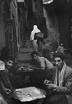 Roger-Viollet | 552558 | Men playing cards in the kasbah. Algiers (Algeria), December 1953. Photograph by Jean Marquis (1926-2019). | © Jean Marquis / Roger-Viollet