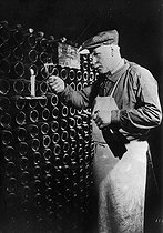 Roger-Viollet | 560390 | Wine making in Champagne. Looking through a glass with candle light, 1936. | © Jacques Boyer / Roger-Viollet