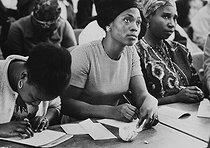 Roger-Viollet | 605841 | African immigrant women. Writing lesson by the charity  Union Féminine Civique et Sociale . Photograph by Janine Niepce (1921-2007). | © Janine Niepce / Roger-Viollet