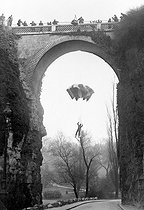 Roger-Viollet | 627571 | René Granveaud sautant en parachute du Pont des Suicidés (27 mètres). Paris, parc des Buttes-Chaumont. | © Roger-Viollet / Roger-Viollet