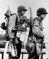 Roger-Viollet | 648744 | Guerre 1939-1945. Front de Normandie. Soldats américains emportant un clairon, partant d'Angleterre en renfort avec leurs équipements, 16 juin 1944. | © Roger-Viollet / Roger-Viollet