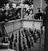 Roger-Viollet | 654884 | Bottle fishing in a fun fair. | © Gaston Paris / Roger-Viollet