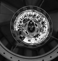 Roger-Viollet | 656143 | Gaston Paris (1903-1964), photographe français, photographiant l'image déformée d'un manège dans un miroir sphérique. France, vers 1937. Photographie de Gaston Paris (1903-1964). | © Gaston Paris / Roger-Viollet