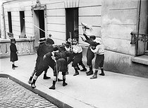 Roger-Viollet | 693972 | Children playing war in the street. Paris, Montmartre, 1910-1920. | © Albert Harlingue / Roger-Viollet