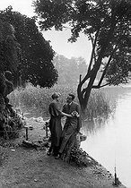 Roger-Viollet | 712483 | Couple au bord d'un étang. (Carte postale fantaisie). France, vers 1920. | © Neurdein / Roger-Viollet