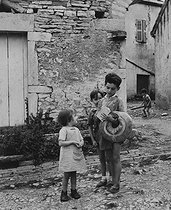 Roger-Viollet | 807150 | Children carrying some bread, crown-shaped or baguette. Rully (Saône-et-Loire), 1950. Photograph by Janine Niepce (1921-2007). | © Janine Niepce / Roger-Viollet