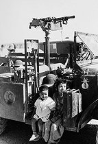 Roger-Viollet | 835366 | Children sitting in a Jeep of the French army near the Morice Line in the Mitidja plain (after André Morice, French Defence Minister), border between Algeria and Tunisia. Algeria, 1958. Photograph by Jean Marquis (1926-2019). | © Jean Marquis / Roger-Viollet