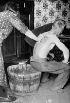 Roger-Viollet | 920842 | Miners in the Pas-de-Calais. Woman washing her husband after the work, about 1920. | © Roger-Viollet / Roger-Viollet