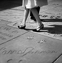 Roger-Viollet | 949770 | Names and prints of famous movie stars in front of the Grauman's Chinese Theatre. Hollywood (Los Angeles, California, United States), March 1964. Photograph by Hélène Roger-Viollet (1901-1985) and Jean Fischer (1904-1985). | © Hélène Roger-Viollet & Jean Fischer / Roger-Viollet