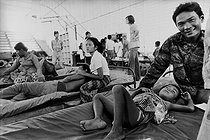 Roger-Viollet | 985470 | Vietnam War. Wounded child at the hospital with his father, he died a few days later. Saigon, 1975. The original caption said: 1/4, the death of a child.  The father seems happy to see his wounded son settled on a bed at the hospital . | © Succession Demulder / Françoise Demulder / Roger-Viollet