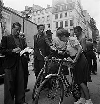 Roger-Viollet | 1052297 | World War II. Liberation of Paris. Beginning of the Parisian insurrection. Distribution of leaflets announcing the publication of the first Free France newspaper. Paris (IInd arrondissement), Rue du Mail, August 21, 1944. Photograph by Jean Roubier (1896-1981). | © Fonds Jean Roubier / Roger-Viollet