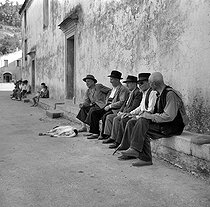 Roger-Viollet | 1084769 | Piana (Corsica). Inhabitants resting themselves in the shade of the church. | © Roger-Viollet / Roger-Viollet