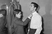 Roger-Viollet | 1251677 | Gilbert Bécaud (1927-2001), French singer-songwriter and musician, in his dressing room with his son before a concert. Versailles (France), November 18, 1964. Photograph from the collections of the French newspaper  France-Soir . Bibliothèque historique de la Ville de Paris. | © BHVP / Roger-Viollet